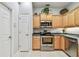 Kitchen featuring a stainless steel range, microwave and dishwasher surrounded by light-colored wood cabinets at 1415 Millbrook Cir, Bradenton, FL 34212