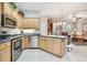 Kitchen with stainless steel appliances and light wood cabinets overlooking the living area at 1415 Millbrook Cir, Bradenton, FL 34212