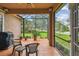 Relaxing screened lanai with outdoor seating, tile flooring, and a peaceful view of the front yard at 1415 Millbrook Cir, Bradenton, FL 34212