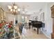 Elegant formal living room and dining area with tile floors, grand piano, and stylish chandelier lighting at 1415 Millbrook Cir, Bradenton, FL 34212