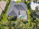 Aerial view showcases the screened-in pool, well-maintained landscaping, and the dark roof of this home at 1508 86Th Nw Ct, Bradenton, FL 34209
