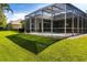 Expansive backyard featuring lush greenery and screened-in pool enclosure, ideal for outdoor recreation and relaxation at 1508 86Th Nw Ct, Bradenton, FL 34209