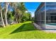 Well-maintained backyard with lush grass and view of screened-in pool enclosure, perfect for outdoor enjoyment at 1508 86Th Nw Ct, Bradenton, FL 34209