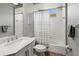 Bright bathroom boasts a shower/tub combo with striped curtain, toilet, and sink with gray accents at 1508 86Th Nw Ct, Bradenton, FL 34209