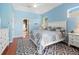 Bedroom boasts bright blue walls, ceiling fan, and view to en-suite bath at 1508 86Th Nw Ct, Bradenton, FL 34209