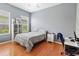 Cozy bedroom with hardwood floors, a ceiling fan, a window view, and a gray plaid bedspread at 1508 86Th Nw Ct, Bradenton, FL 34209