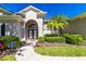 Inviting home featuring an arched entryway, lush tropical landscaping, and a neatly maintained walkway at 1508 86Th Nw Ct, Bradenton, FL 34209