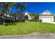 Beautiful front exterior with lush green lawn, decorative plants and bushes, framed by large palm trees at 1508 86Th Nw Ct, Bradenton, FL 34209
