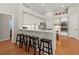 Modern kitchen features white cabinetry, stainless appliances, breakfast bar, and wood floors at 1508 86Th Nw Ct, Bradenton, FL 34209
