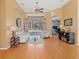Cozy living room with hardwood floors, neutral furniture, and a view of the pool area through sliding glass doors at 1508 86Th Nw Ct, Bradenton, FL 34209