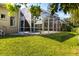 A beautiful backyard and screened-in pool with lush green grass and tropical trees, perfect for entertaining at 1508 86Th Nw Ct, Bradenton, FL 34209