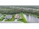 Aerial view features the back of the home with spacious lawn backing up to a pond and mature trees at 16038 39Th E Gln, Parrish, FL 34219