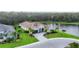 Aerial view features the front of the home with beautiful landscaping, pond view, and paver driveway at 16038 39Th E Gln, Parrish, FL 34219