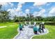 A gorgeous backyard features a fire pit, putting green, and beautifully manicured lawn at 16038 39Th E Gln, Parrish, FL 34219