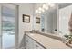 Bright bathroom featuring a single sink vanity with quartz countertops, and a view of the outdoors at 16038 39Th E Gln, Parrish, FL 34219