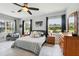 Comfortable bedroom boasts a ceiling fan, tile floors, and a serene view of the outdoors from two large windows at 16038 39Th E Gln, Parrish, FL 34219
