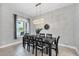 Bright dining room showcases a stylish chandelier, long black table with seating for six, and window with view at 16038 39Th E Gln, Parrish, FL 34219
