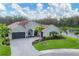 Beautiful single-story home features a three-car garage and a well-manicured lawn with vibrant landscaping and pond view at 16038 39Th E Gln, Parrish, FL 34219