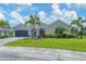 Beautiful single-story home features a three-car garage and a well-manicured lawn with vibrant landscaping and pond view at 16038 39Th E Gln, Parrish, FL 34219