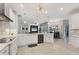 Open kitchen with stainless steel appliances, white cabinets, and views of the living area and outdoor dining at 16038 39Th E Gln, Parrish, FL 34219