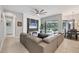Comfortable living room features a sectional sofa, a wall-mounted TV, and access to the outdoor living area at 16038 39Th E Gln, Parrish, FL 34219