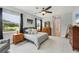 Comfortable main bedroom with tile flooring, ceiling fan, dresser, nightstands and window with view at 16038 39Th E Gln, Parrish, FL 34219