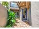 Charming courtyard entrance featuring a blue door, brick pathway, and lush tropical plants for a welcoming ambiance at 200 Cocoanut Ave # 1, Sarasota, FL 34236