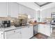 Bright kitchen featuring white cabinets, granite countertops, stainless steel appliances, and a stylish backsplash at 200 Cocoanut Ave # 1, Sarasota, FL 34236