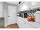 Utility room with ample white cabinetry, countertop space, and tiled floor at 200 Cocoanut Ave # 1, Sarasota, FL 34236
