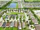 An aerial view of a neighborhood with lush green lawns and a large lake nearby at 2118 Song Sparrow Ct, Ruskin, FL 33570