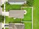 Aerial view of the backyard with a patio, firepit, and green lawn surrounded by a white fence at 2118 Song Sparrow Ct, Ruskin, FL 33570