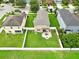Aerial view of a large backyard with a patio and firepit surrounded by a white fence at 2118 Song Sparrow Ct, Ruskin, FL 33570
