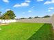 The wide-open backyard features a lush green lawn, a white fence, and is perfect for outdoor activities at 2118 Song Sparrow Ct, Ruskin, FL 33570