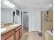 Bathroom with double sinks, tile floor, glass shower, and soaking tub at 2118 Song Sparrow Ct, Ruskin, FL 33570