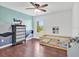 Stylish bedroom with mountain-themed wall art, modern ceiling fan, and wood-look flooring at 2118 Song Sparrow Ct, Ruskin, FL 33570