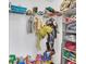 Organized closet with hanging clothes, shelving, and a variety of toys and accessories at 2118 Song Sparrow Ct, Ruskin, FL 33570