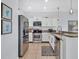 Modern kitchen with stainless appliances, granite counters, white cabinets, and tile floors, ideal for cooking at 2118 Song Sparrow Ct, Ruskin, FL 33570