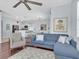 Open living room with a ceiling fan, modern blue sofa, and adjoining kitchen at 2118 Song Sparrow Ct, Ruskin, FL 33570