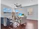 Modern living room with large windows, stylish seating, ceiling fan and a TV showing a beach scene at 2118 Song Sparrow Ct, Ruskin, FL 33570
