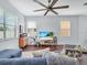 Inviting living room with a comfortable sectional sofa, ceiling fan, and modern entertainment setup, showing a beach scene at 2118 Song Sparrow Ct, Ruskin, FL 33570