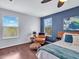 Relaxing main bedroom featuring warm hardwood floors, ceiling fan and window views at 2118 Song Sparrow Ct, Ruskin, FL 33570
