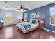 Spacious bedroom with hardwood floors, blue accents, ceiling fan and plenty of natural light at 2118 Song Sparrow Ct, Ruskin, FL 33570