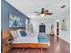 Main bedroom with hardwood floors, navy dresser, and a view into the main bath at 2118 Song Sparrow Ct, Ruskin, FL 33570