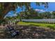 Serene backyard featuring a fenced-in lawn area and shaded seating, perfect for relaxation and outdoor enjoyment at 2400 Ezzell Ct, Sarasota, FL 34237