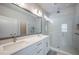 Modern bathroom with a double sink vanity, a large mirror, and a glass-enclosed shower with sleek fixtures at 2400 Ezzell Ct, Sarasota, FL 34237