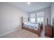 Cozy bedroom with a wood-frame bed, plush carpeting, and natural light streaming through two large windows at 2400 Ezzell Ct, Sarasota, FL 34237