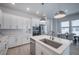 Modern kitchen featuring a center island, stainless steel appliances, and white cabinetry at 2400 Ezzell Ct, Sarasota, FL 34237