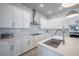 Well-lit kitchen boasting white cabinets, modern appliances, and sleek countertops at 2400 Ezzell Ct, Sarasota, FL 34237