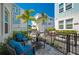 Inviting patio with comfortable seating, lush landscaping, and a view of modern townhomes against a clear blue sky at 2400 Ezzell Ct, Sarasota, FL 34237