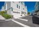 New townhomes on a sunny corner lot with a street sign and tropical landscaping along a private road at 2400 Ezzell Ct, Sarasota, FL 34237